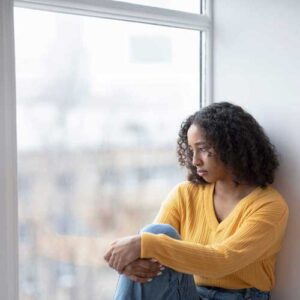 Sad individual looking out window